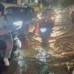 Vehicles move through a waterlogged Bengaluru road in a video shared by Whitefield Traffic Police about Vibgyor School Road towards Balagere T Junction.