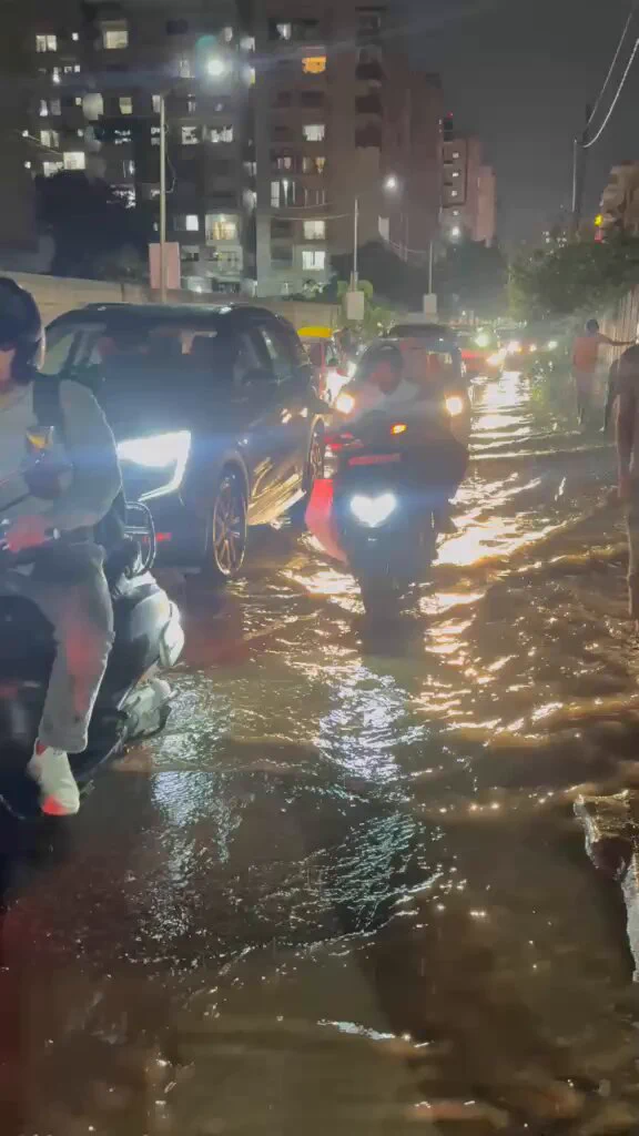 Vehicles move through a waterlogged Bengaluru road in a video shared by Whitefield Traffic Police about Vibgyor School Road towards Balagere T Junction.