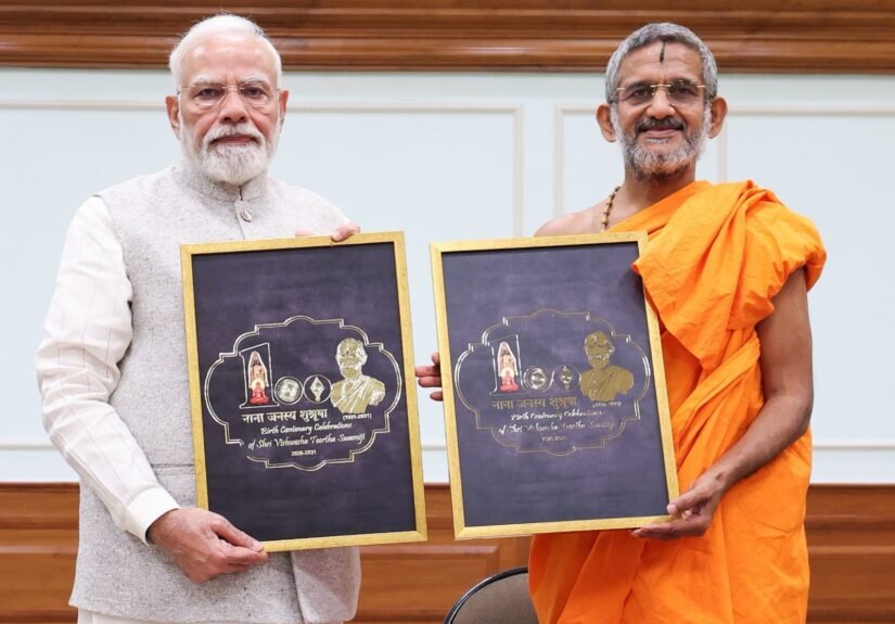 Prime Minister Narendra Modi with Pejawar Matha seer Vishwaprasanna Tirtha Swamiji at the birth-centenary logo unveiling