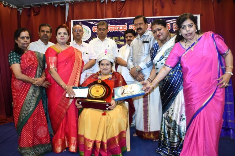 Felicitation ceremony at the Akhila Karnataka Brahmana Mahasabha with a seated honouree holding an award