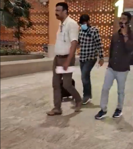 A masked man walking with two other men in the supplied image accompanying the Bengaluru fake medicine case report