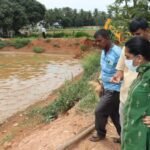 Officials inspect a catfish pond during the Hoskote operation