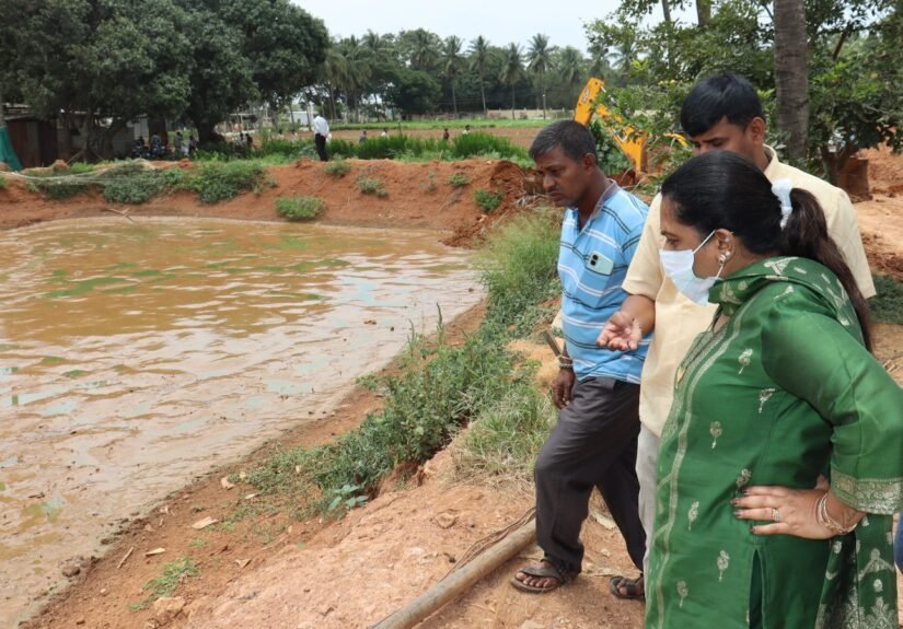 Officials inspect a catfish pond during the Hoskote operation