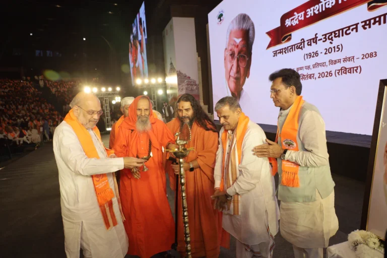 Amit Shah lights a ceremonial lamp with other participants at the Ashok Singhal birth centenary event at Bharat Mandapam