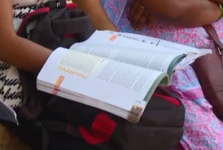 Person reading an open textbook.