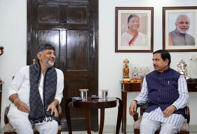 D.K. Shivakumar and Pralhad Joshi seated during their meeting.