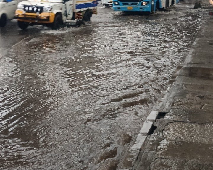 Vehicles move through waterlogging near Kasturi Nagar down-ramp toward Tin Factory in Bengaluru