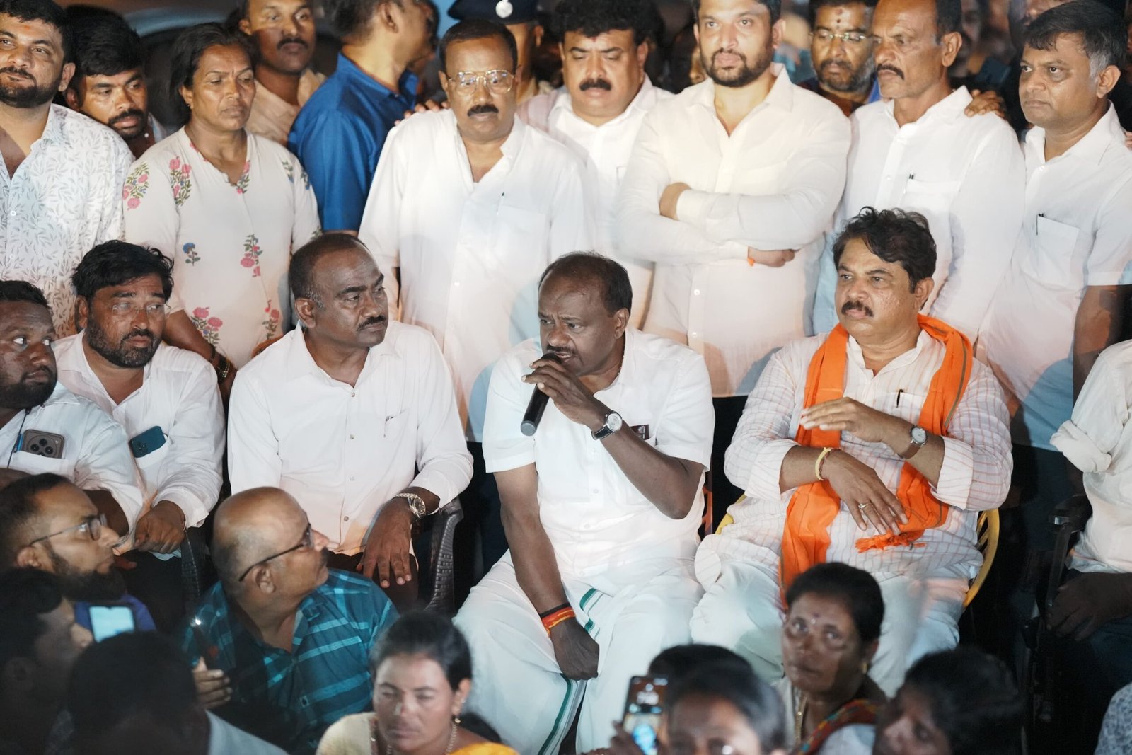 H D Kumaraswamy speaks with disability-rights marchers beside R Ashoka near Bidadi
