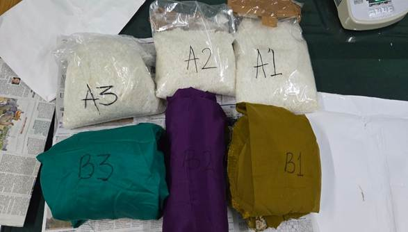 Three packets of white crystalline substance labelled A1, A2 and A3 above three coloured bags — PIB India photograph