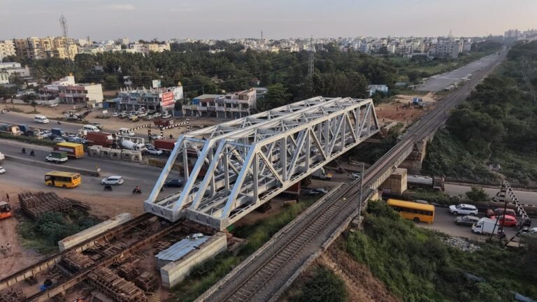 Aerial view of the new white railway bridge structure beside the existing bridge over NH-44 near Chandapura
