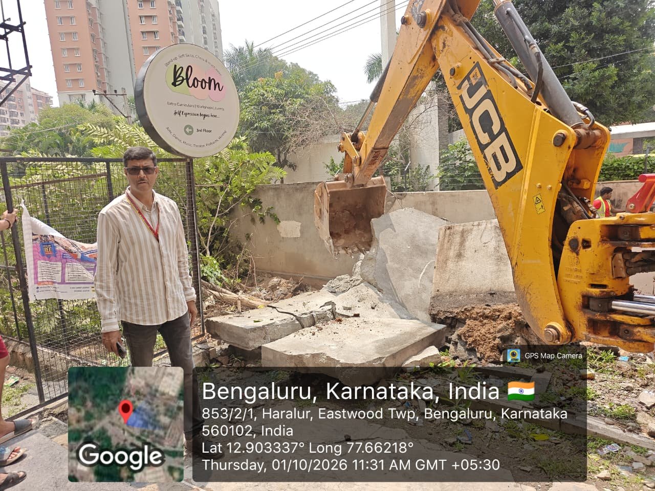 Excavator removes a compound wall during Haralur stormwater-drain encroachment clearance