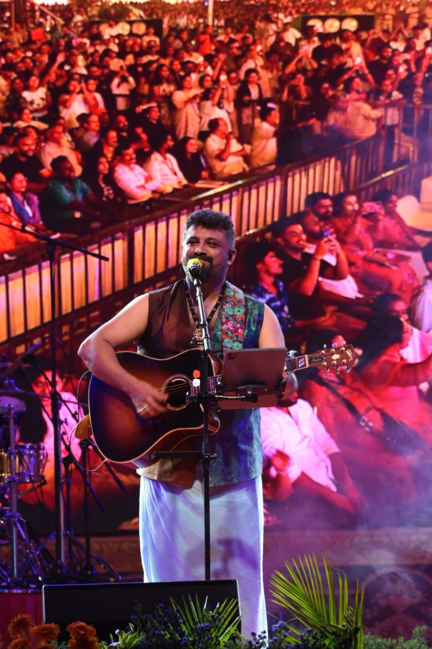 Raghu Dixit singing and playing guitar at the Mysuru Palace Dasara concert.