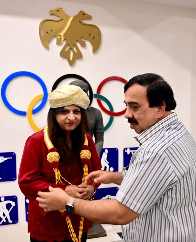 Nita Bhushan wearing a Mysore peta as K. Govindaraj honours her at the Karnataka Olympic Association