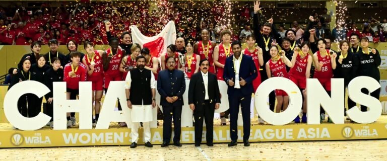 Denso Iris players celebrate their Women’s Basketball League Asia championship in Bengaluru with the Japanese flag and trophy.