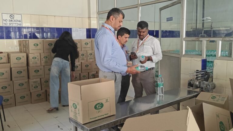 Officials check packaged drinking-water bottles during a Karnataka food-safety inspection