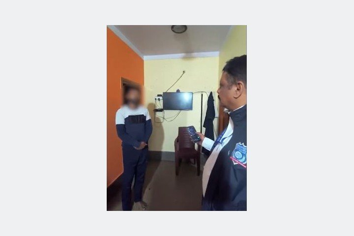 A CCB officer during a check in the official J.J. Nagar operation video, with the other person’s face blurred by police