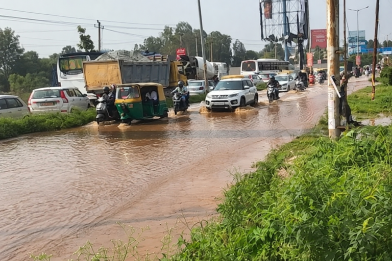 Vehicles pass through standing water at Kannuru junction towards Bagaluru Road in Bengaluru