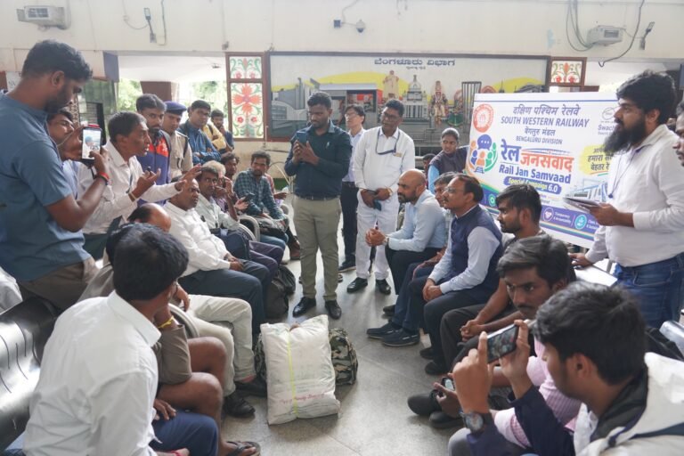 Passengers and South Western Railway officials seated in discussion at the Rail Jan Samvad programme at KSR Bengaluru