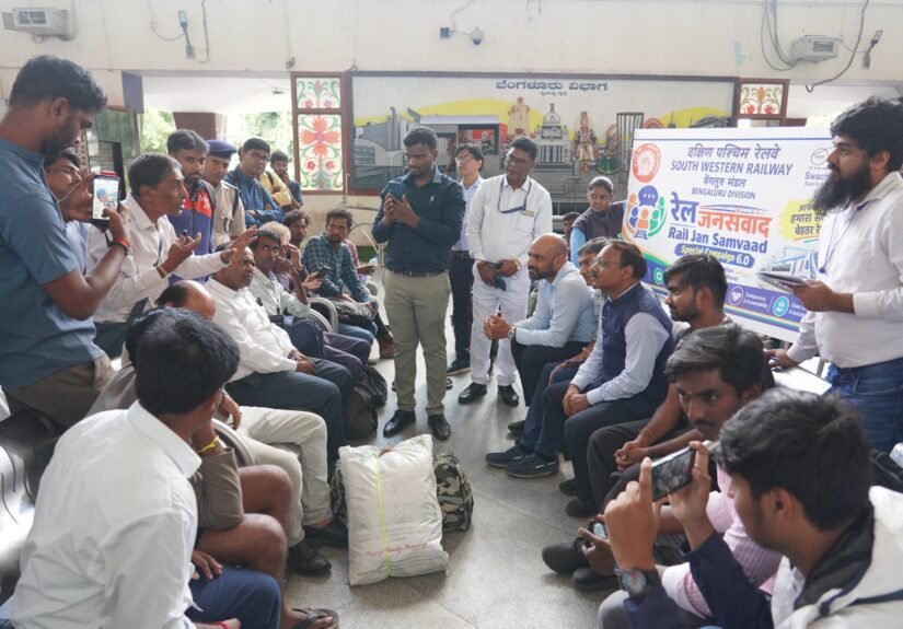 Passengers and South Western Railway officials seated in discussion at the Rail Jan Samvad programme at KSR Bengaluru