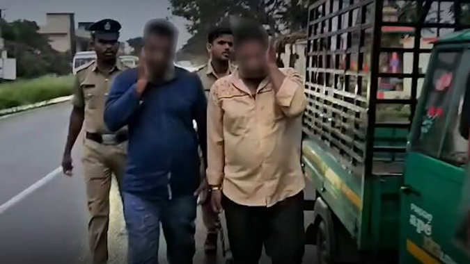 Police escort two men whose faces are blurred in the original Ramanagara robbery-case footage